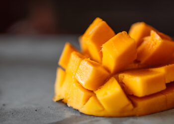 a sliced mango cubes on gray surface